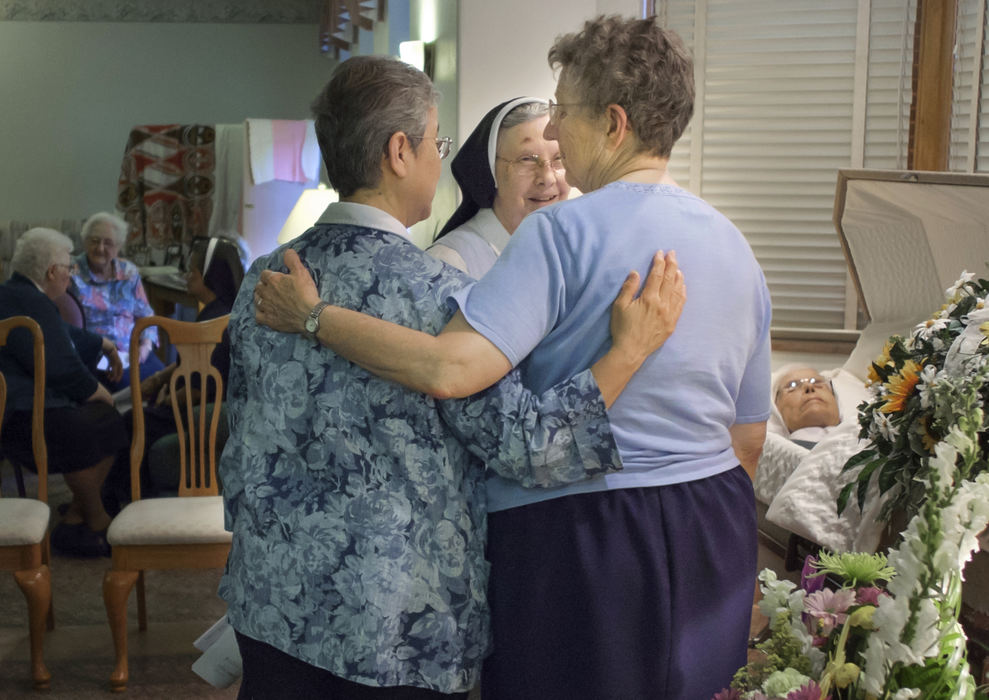 Third Place, Ohio Understanding Award - Andy Morrison / The (Toledo) BladeSr. Elizabeth Maria Garcia, left, Sr. Mary Lucy Suter, and Sr. Mary de Porres Westrick, fondly remember Sr. Mary Virginia Wenninger, 97, during her viewing at Sisters of Notre Dame Toledo Province.