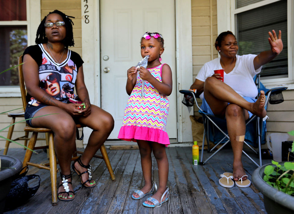 Award of Excellence, Ohio Understanding Award - Lisa DeJong  / The Plain DealerTashara Smith, 4, sips on a juice pack on a blistering 90-degree summer day. Her mother Juevera Smith is left and her grandmother Quadie Smith, right, waves to a passerby at their home on E. 84th Street. There are strong, multi-generational family ties in the Hough neighborhood. It is a place most people drive past, not through, rarely taking time to explore. Folks who live there, though, have a story to tell. They want people to see their neighborhood like they do, as a diamond in the rough.