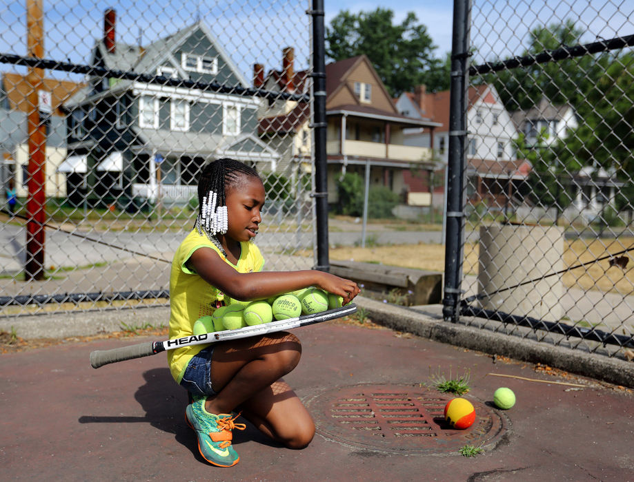 Award of Excellence, Ohio Understanding Award - Lisa DeJong  / The Plain DealerTennis lessons are not the first thing outsiders consider when they talk about Hough where 66 percent of children live in poverty. Shantel Williams, 7, picks up tennis balls during the Inner City Tennis Clinics summer camp on the tennis courts of Cleveland Thurgood Marshall Recreation Center in the Hough neighborhood. The Inner City Tennis Clinics is a non-profit organization dedicated to providing urban youths with guidance, education and recreation during the summer months. Tennis is the main focus, but the kids also attend literacy, wellness and creativity classes. 