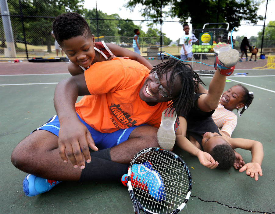 Award of Excellence, Ohio Understanding Award - Lisa DeJong  / The Plain DealerTennis instructor Rufus Harvey, 17, plays with the kids during the Inner City Tennis Clinics summer camp on the tennis courts of Cleveland Thurgood Marshall Recreation Center in the Hough neighborhood. Harvey started as a tennis student when he was 12 years old in 2011.