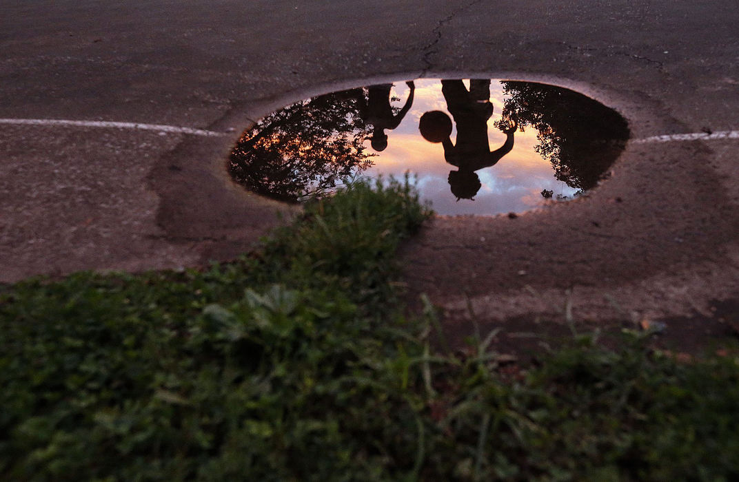 Third Place, Pictorial - Brooke LaValley / The Columbus DispatchTeenagers play basketball during sunset as reflected in a puddle at Schiller Park in Columbus.