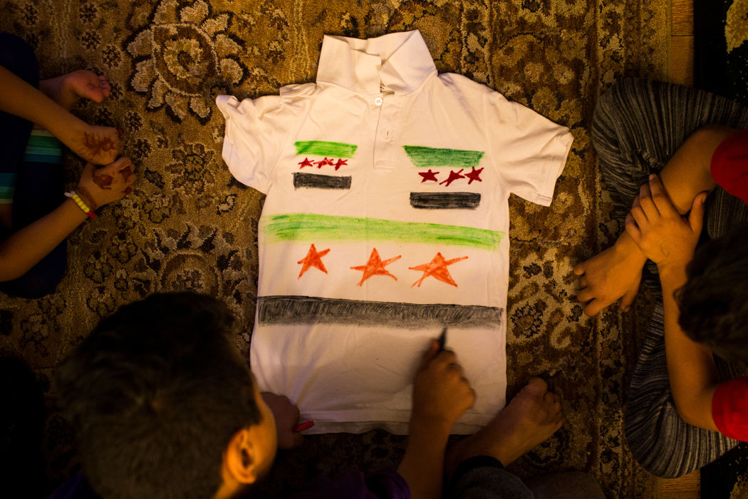 First Place, Photographer of the Year - Large Market -  / The Enquirer/Meg VogelHasan Alhamoud draws a Syrian flag on one of his uniform shirts on Thursday, October 6, 2016.