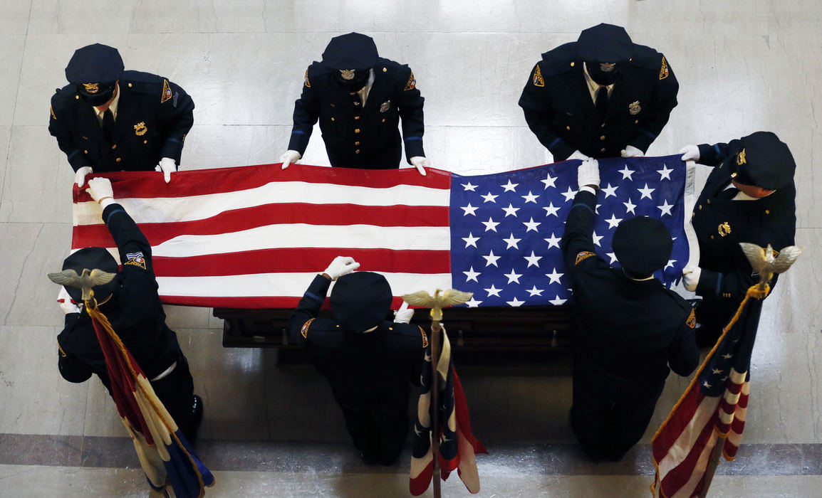 Award of Excellence, Photographer of the Year - Large Market - Gus Chan / The Plain DealerMembers of the Ohio State Patrol drape the casket of the late George Voinovich in the Cleveland City Hall rotunda.  The troopers were preparing to transport the body to it's final resting spot at All Souls Cemetary.