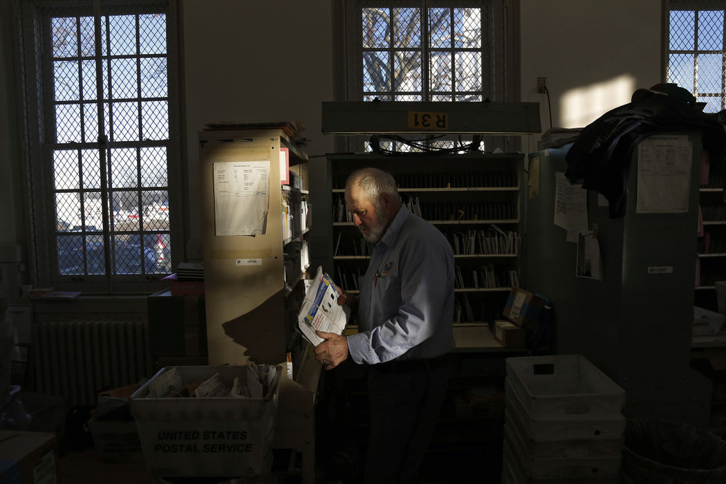 Second Place, Photographer of the Year - Large Market - Kyle Robertson / The Columbus Dispatch Marysville postman John Burson organizes the mail before heading out on his route around Marysville on December 15, 2016.  Burson has been delivering mail for 45 years and this will be his last week and the same downtown route since 1984.  