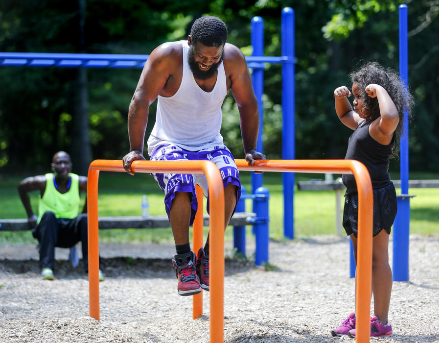 Third Place, Photographer of the Year - Large Market - Andy Morrison / The (Toledo) BladeTeiniya Taroxler, 7, flexes her muscles as she watches her father Tijuan Taroxler, Toledo, work out at Ottawa Park in Toledo, Ohio.