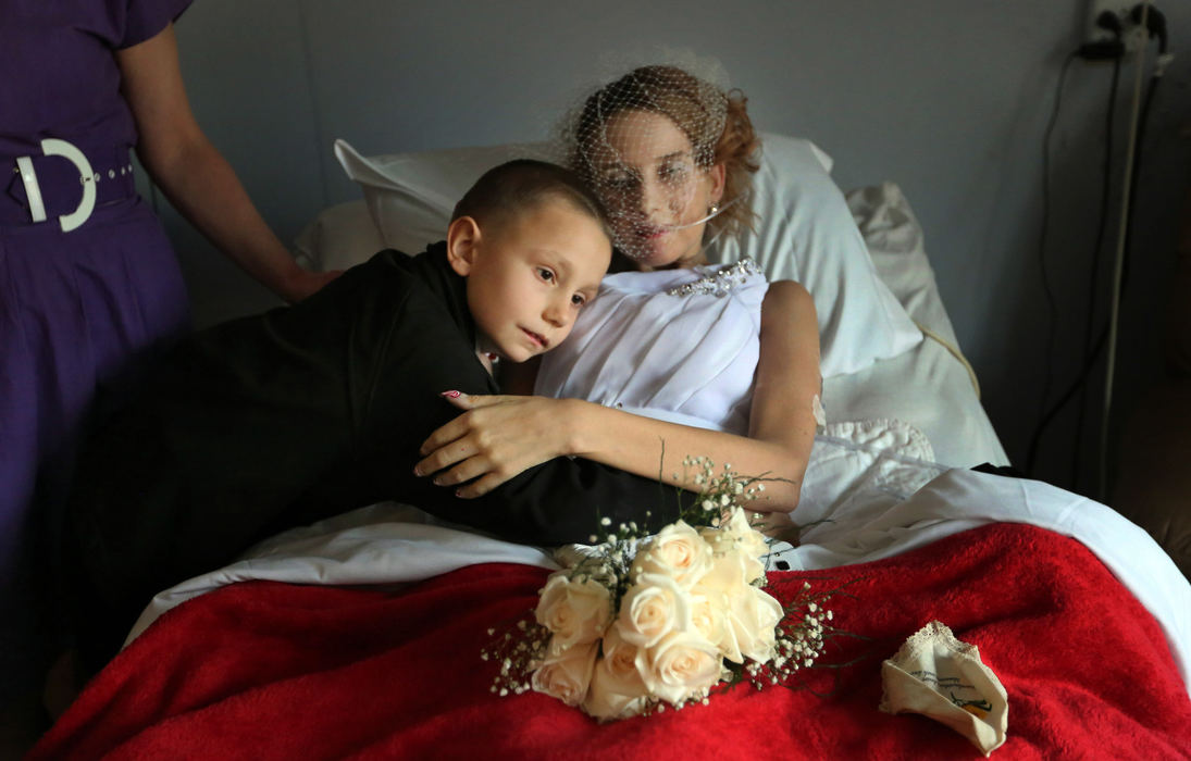 Award of Excellence, Photographer of the Year - Large Market - Gus Chan / The Plain DealerAmber, a terminally ill resident at Malachi House, rests in bed as she gets a hug from her stepson, Zachery, 7, before her wedding ceremony.  Malachi House serves the needs of those who are terminally ill. It was Amber's final wish to be married before she died.