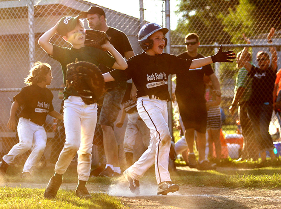 First Place, Photographer of the Year - Small Market - Jessica Phelps / Newark AdvocateDan's Family Pizza celebrates after beating Edward Jones in the consolation game. Dan's came back from a 6-1 lead to tie up the game in the sixth inning, taking the game to the seventh where they scored the last run needed for victory. 