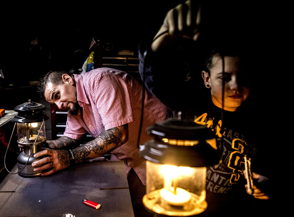 First Place, Photographer of the Year - Small Market - Jessica Phelps / Newark AdvocateBill "Sparky" Rector and his ten-year old son, Nyciah, light lanterns in their garage to help them see better while creating a snowman to put in their front yard. Rector says he wants to take advantage of every moment he has with his children now that he is sober. 