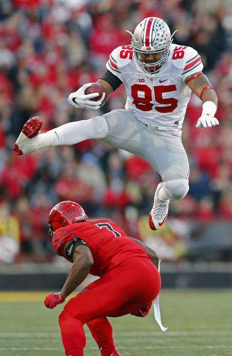 Award of Excellence, Sports Action - Kyle Robertson / The Columbus DispatchOhio State Buckeyes tight end Marcus Baugh (85) leaps over Maryland Terrapins defensive back JC Jackson (7) after making a catch during the first half at Maryland Stadium in College Park, Md.