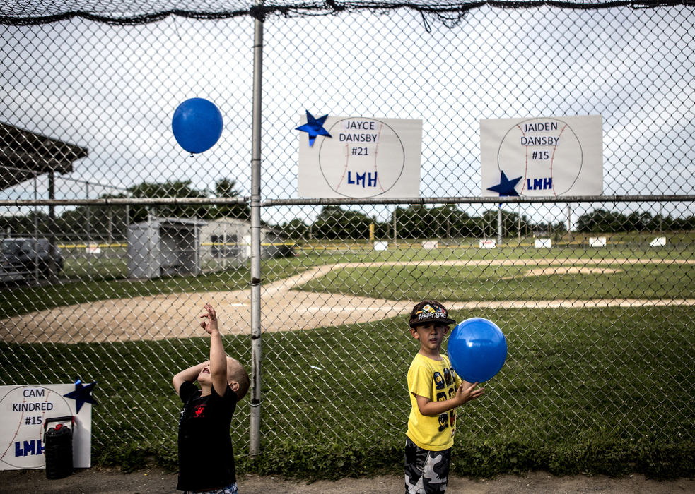First Place, Ron Kuntz Sports Photographer of the Year - Jessica Phelps / Newark AdvocateSiblings of players from the LMH team play around with balloons while their parents decorate the dugouts and fences for the championship game. LMH lost the final game to Newark Optometry. 