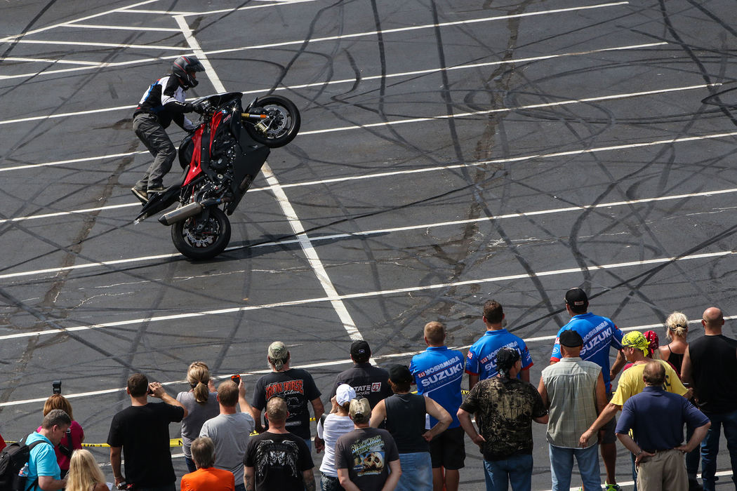 First Place, Chuck Scott Student Photographer of the Year - Andrea Noall / Kent State UniversityStunt rider, Chris “Teach” McNeil, of Maine, performs a wheelie while standing on the seat of his bike as a crowd cheers on outside of the Hard Rock Rocksino in Northfield on Sunday, August 28, 2016. 