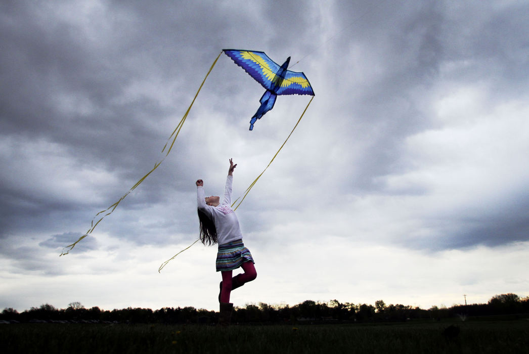 Feature - 1st place - Brooklynn Blower reaches for a kite as it comes close to the ground at the Groveport Recreation Center. Blower had been flying the kite with her mother Rachael Berne and family friend Brad Kitts when she got tired of just standing there, so she started running after the kite and trying to grab it from the sky each time it dropped close enough.  (Neal C. Lauron / The Columbus Dispatch)