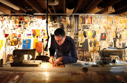 Portrait - 2nd place - Artist Chris Pekoc. Artist Chris Pekoc works in his basement studio at the massive table he constructed, with his two sewing machines on either side in the Tremont neighborhood. (Lisa DeJong / The Plain Dealer)