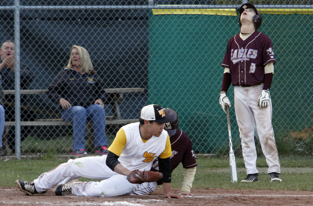 Sports Feature - 3rd placeNew Albany's Grant Oehler (9) reacts after teammate Jared Mandel is tagged out at home by Watkins Tony Winters after trying to score when a pitch got past the catcher.  This ended the New Albany's threat in the sixth.  Watkins won 2-1.  (Lorrie Cecil / ThisWeek Newspapers)