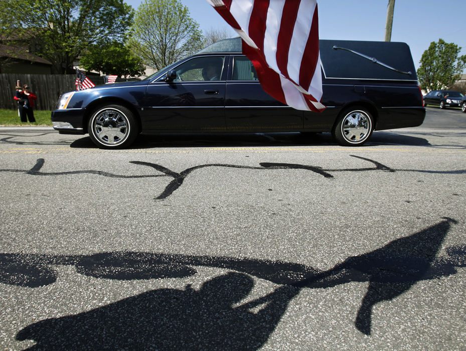 Story - 2nd placeThomas Madine waves an American Flag as the hearse with the casket of Capt. Nicholas Rozanski leaves Saint Joan of Arc Catholic Church after a funeral mass in Powell.  Thomas a citizen of Westerville wanted to pay his respect to Rozanski after reading about him in the paper.    (Kyle Robertson / The Columbus Dispatch)