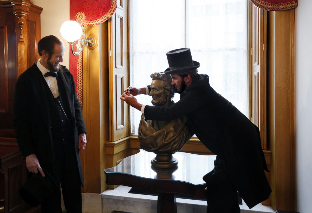 Feature - 2nd placeLincoln impersonator Rick Miller (right) of Cranberry Township, Pa. takes a photo of himself with a bust of Lincoln while Steve Wood (left) of Claremont NH. looks on in the Governors ceremonial office at the Statehouse.  (Eric Albrecht / The Columbus Dispatch)