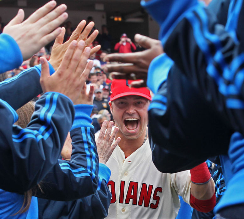 Sports Feature - 1st placeCleveland Indians Nick Swisher funnels through a wave of high-fives after being introduced on Opening Day at Progressive Field before the game against the New York Yankees.  (Phil Masturzo / Akron Beacon Journal)