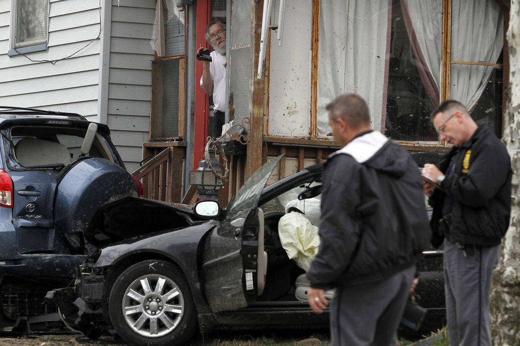 Spot News - 1st placeHome owner Tim Neal, 65, watches and records footage with a video camera from his front door as Lorain police investigate the scene of a crash the occurred in his front yard at 328 8th Street in Lorain. Witnesses stated that a car chase resulted in the crash before one man was taken to the hospital by ambulance. Neal's Toyota RAV4 and his wife's motorized wheelchair in its trunk were damaged when it was struck by the Chrysler Sebring.  (Sam Greene / The (Lorain) Morning Journal)