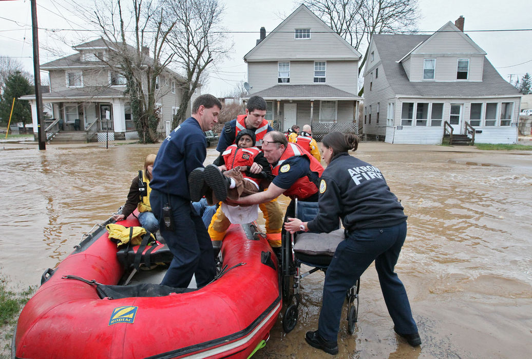 Spot News - 2nd placeYvonne Mayfield, 58, is lifted from a boat by Akron Firefighters rescued her from her North Valley Street home after a water main break flooded the area near North Street in Akron.  (Phil Masturzo / Akron Beacon Journal)