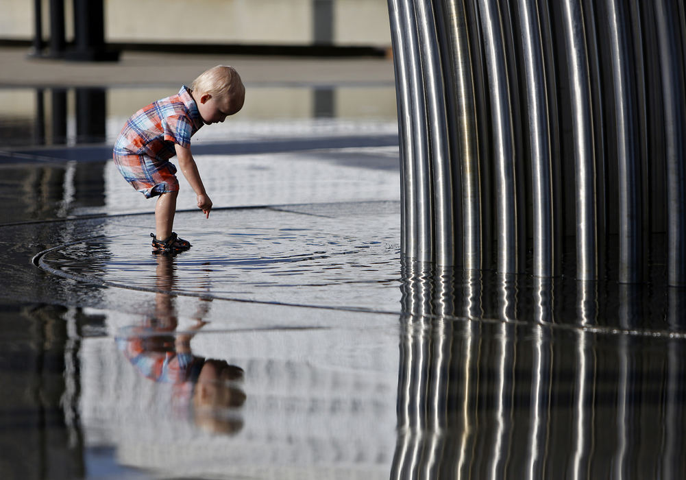 Feature - 2nd place - Benjamin Stephenson of Columbus plays in the puddles left in the fountains at Bicentennial Park on Easter Sunday.  (Sam Greene / The Columbus Dispatch)