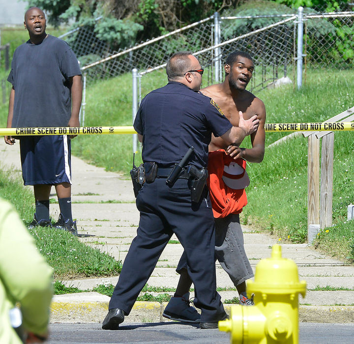 Spot News - 3rd place - A member of the Springfield Police Division tries to calm down a visibly upset man as he tries to rush into a crime scene at the intersection of South Lowry and Grand Avenues where another man was fatally shot.  (Bill Lackey / Springfield News-Sun)