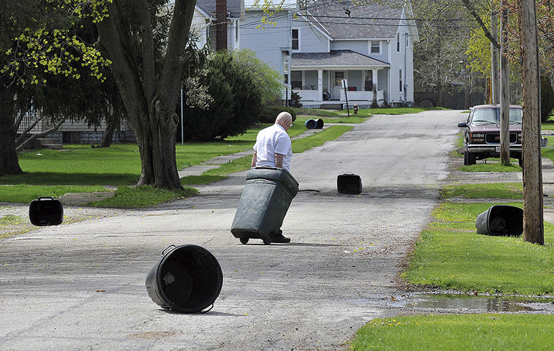 Feature - 3rd place - Joe Weiler of Bucyrus brings his garbage can back to the house after high winds blew it into the street.  40 MPH winds were officially registered were in advance of a cold front. (Mitchell Pe Masilun / Bucyrus Telegraph Forum)