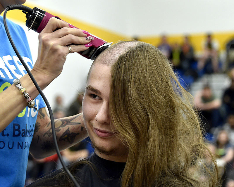 Feature - HM - Jaren Davidson, a student at Springfield High School, gets his hair shaved off during a St. Baldrick's charity event in the school gym. With the help of local barbers and stylists, nine students had their head shaved to raise money and increase awareness of childhood cancer. The students raised over $2.000 for the charity.  (Bill Lackey / Springfield News-Sun)