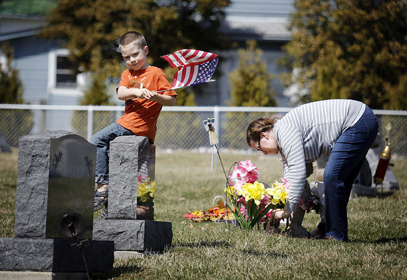 General News - 1st place - Four-year-old Isaiah Ross plays with a flag while his mom, Heather Ross, fixes the flowers on her grandmother's grave at the Galena Cemetery. Berkshire Township says it will no longer maintain Galena Cemetery, after doing so for more than 200 years.  (Jonathan Quilter / The Columbus Dispatch)