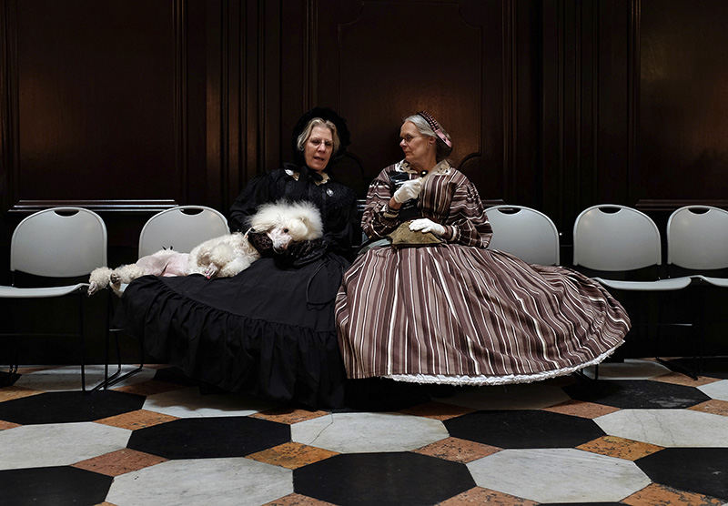 General News - 2nd place - Roberta Mazur, left, of Alliance holds her poodle Yvette while talking to Elaine Shimp of Cambridge inside the rotunda of the Ohio Statehouse during the 150th anniversary of the repose of President Abraham Lincoln. (Kyle Robertson / The Columbus Dispatch)