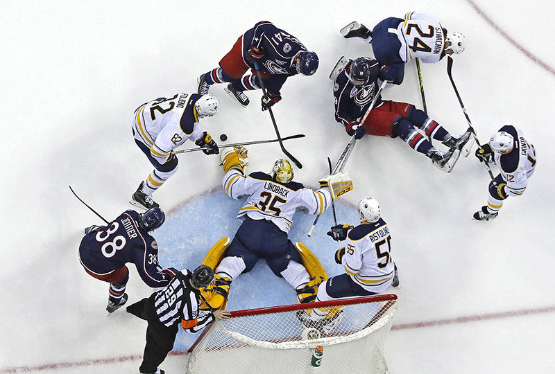 Sports - 2nd place - A scrum opens up in front of the net as players fall to the ice in the first period of a game between the Columbus Blue Jackets and the Buffalo Sabres at Nationwide Arena in Columbus. The Blue Jackets defeated the Sabres 4 - 2.  (Eamon Queeney / The Columbus Dispatch)