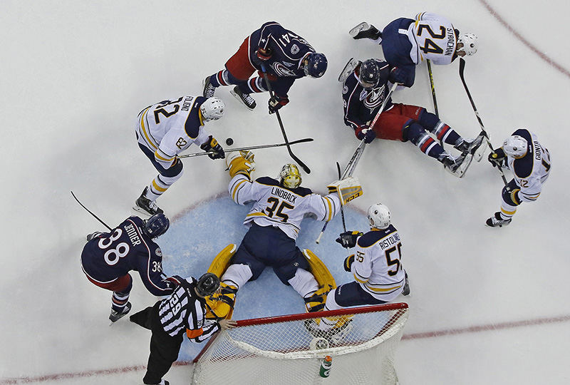 Story - 2nd place - A scrum opens up in front of the net as players fall to the ice in the first period of a game between the Columbus Blue Jackets and the Buffalo Sabres at Nationwide Arena in Columbus. The Blue Jackets defeated the Sabres 4 - 2.  (Eamon Queeney / The Columbus Dispatch)