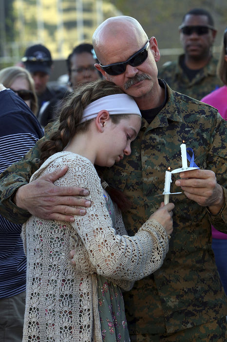 General News - 1st place - Swat officer Jim Sanford consoles his daughter Mollie Sanford, 12, during the vigil for fellow officer Steven Smith at the Columbus Police Memorial. Officer Smith was killed in the line of duty during a swat raid in which a gunman had barricaded himself in a house and had been setting fires. (Eric Albrecht / The Columbus Dispatch)