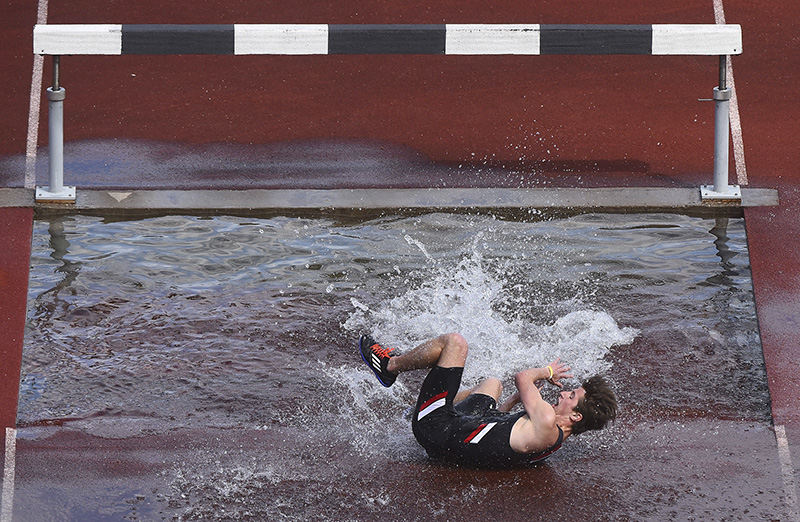 Sports - HM - Cincinnati's Nick Grismer rolls out of the water pit during the second lap of the 3000 meter steeplechase event at the Oliver Nikolof Invitational track meet hosted by the University of Cincinnati. Grismer went on to finish 4th overall with a time of 9:59:16 (Erik Schelkun / Elsestar Images)