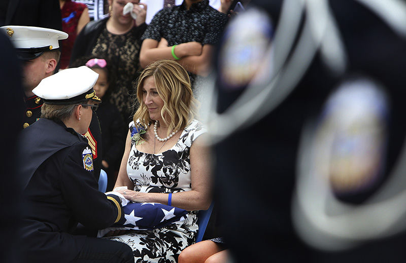 Story - 1st place - Columbus Police Chief Kim Jacobs presents the flag to Lisa Smith whose husband Columbus Police Steve Smith officer was killed in the line of duty after the funeral service. (Eric Albrecht / The Columbus Dispatch)