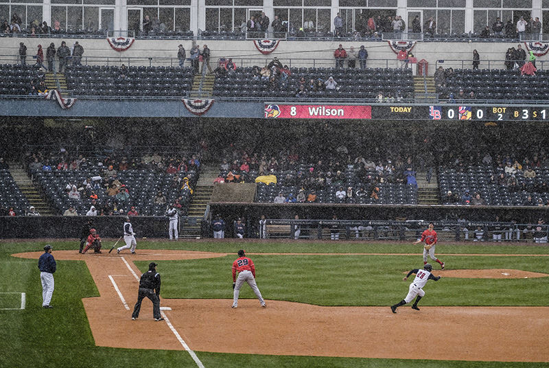    Story - 3rd place - Snow falls as Toledo Mud Hens' Bobby Wilson (8) hits a double to drive in a run during the second inning of their home opener against the Louisville Bats.  (Andy Morrison / The (Toledo) Blade)