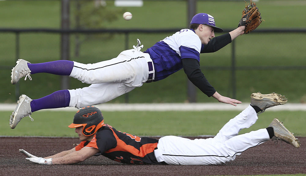 Sports - 1st place - Jackson's Kyle Nicolas leaps to field the ball as Hoover's Donnie Genetin steals second base in the third inning of their game  in Jackson Township.  (Scott Heckel / The Repository)