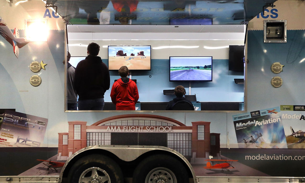 Feature - HMNoah Bellville (left) Alexander Weiss (center) and Benjamin Weiss, 12, use a AMA flight simulator during the 65th annual The Toledo Show: R/C Model Expo at the SeaGate Convention Centre. (Amy E. Voigt/The Blade)