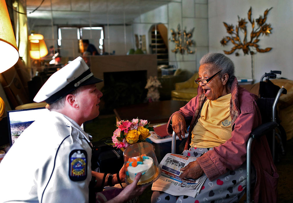 General News - 1st placeColumbus police officer Joshua Good drops off a birthday cake, flowers and gifts to Margaret Belcher at her house in Columbus.  Belcher had her home broken into twice in two days last week.  Belcher's birthday is tomorrow but officer Joshua Good has the day off.   (Kyle Robertson/The Columbus Dispatch)