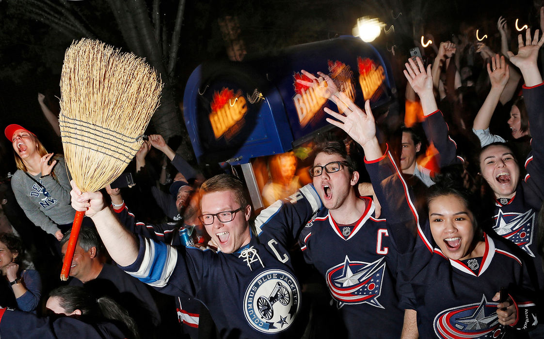 Sports Feature - 1st placeSean Clawson (broom) and friend Seth Deere celebrates a sweep as Blue Jackets win against the Tampa Bay Lightning while watching it the R Bar in the Arena District. (Eric Albrecht/The Columbus Dispatch)