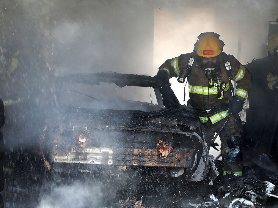 Spot News - 1st placeA member of the Springfield Fire Division sifts through the smoldering remains of a 1981 Corvette that was destroyed in a detached garage fire on Snyder Street. (Bill Lackey/Springfield News-Sun)