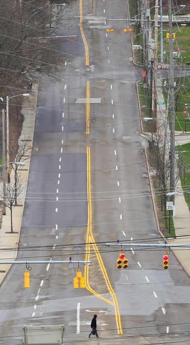 Feature - HM - A lone pedestrian crosses a nearly empty Howard Street in Akron. Jeff Lange / Akron Beacon Journal