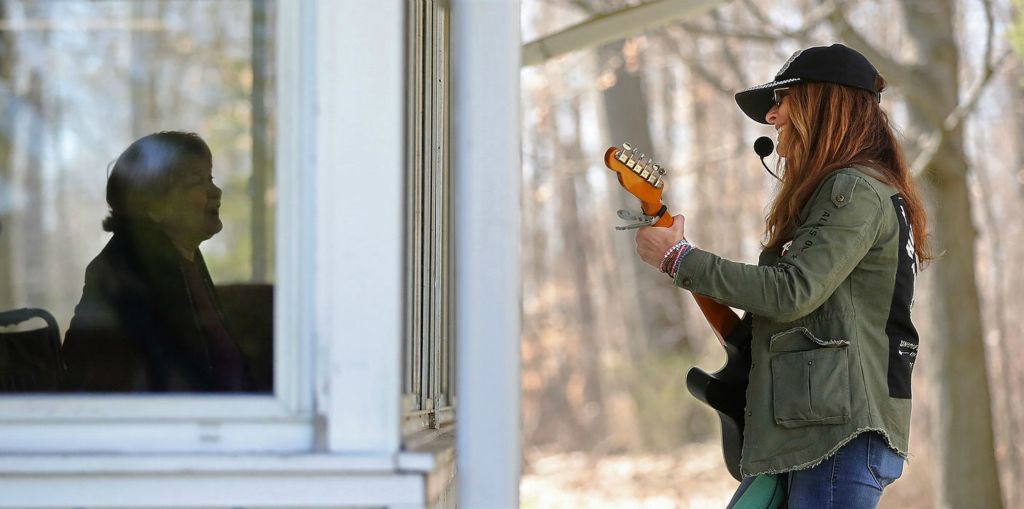 Feature - HM - Musician Brenda Boulton (right) plays a mini window concert for residents at Life Care Center of Medina. Jeff Lange / Akron Beacon Journal