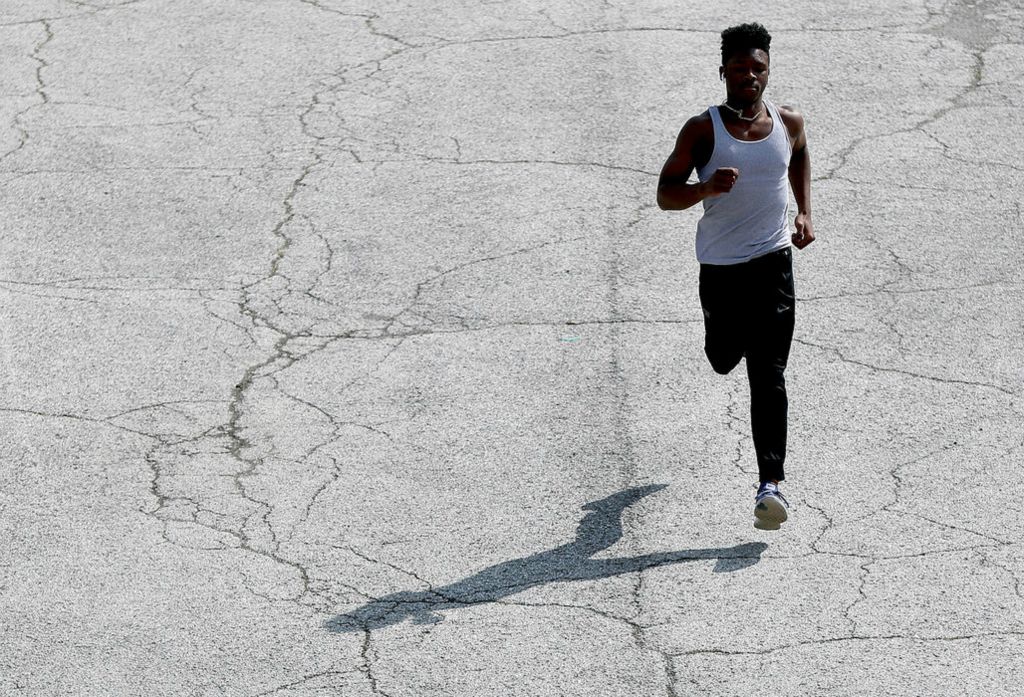 Sports Feature - 1st place - Westerville Central track athlete DJ Johnson, 17, exercises to keep in shape during the spring sports postponement period due to the COVID-19 coronavirus at Hoover Reservoir Park in Westerville. Shane Flanigan / ThisWeek Community News