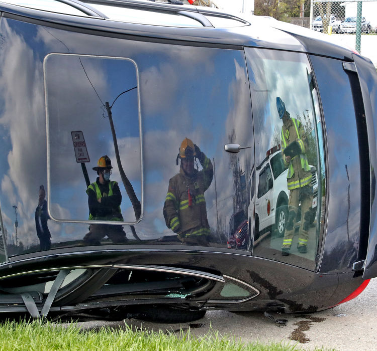 Spot News - 3rd place - Springfield firefighters are reflected in the roof of an overturned car as they wait for a tow truck following a three car accident at the intersection of Columbia Street and Plum Street. The driver of the flipped car was transported to the hospital with non-life threatening injuries. The drivers of the two other vehicles were not injured.  Bill Lackey / Springfield News-Sun