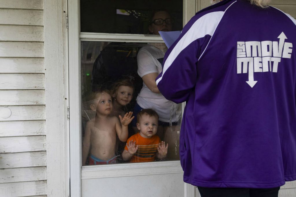 Story - 1st place - Joy Dickason (right) and her three children Koda, 2, (left) Elsa, 4, (center) and Zayn, 1, talk with The Movement captain Tina Butts about setting up an appointment for Joy to get vaccinated in Toledo. (Rebecca Benson / The Blade)