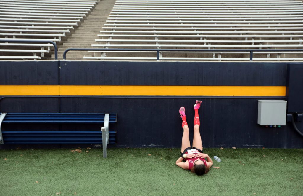 Sports Feature - 2nd place - Michelle Hanley-Kimmerle lays on the ground to recover in the Glass Bowl Stadium after running The Mercy Health Glass City Marathon. (Amy E. Voigt / The Blade)