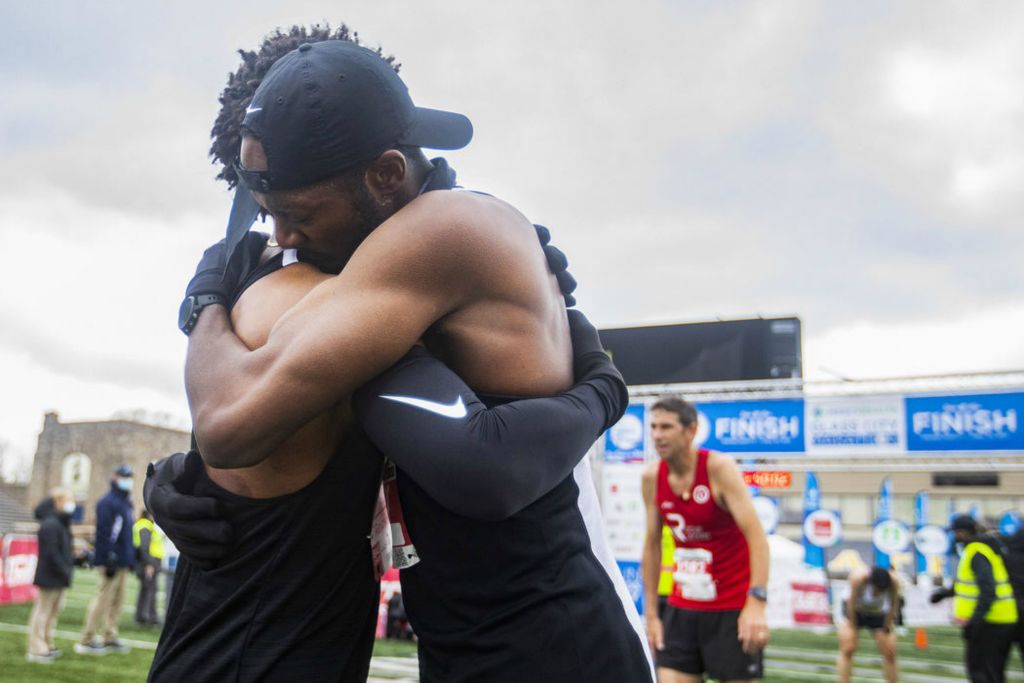 Sports Feature - 3rd place - Thomas Bailey, of Farmington Hills, Mich. (left) and Lance Woods, of Detroit, hug after completing the Mercy Health Glass City Marathon at the University of Toledo. (Rebecca Benson / The Blade)