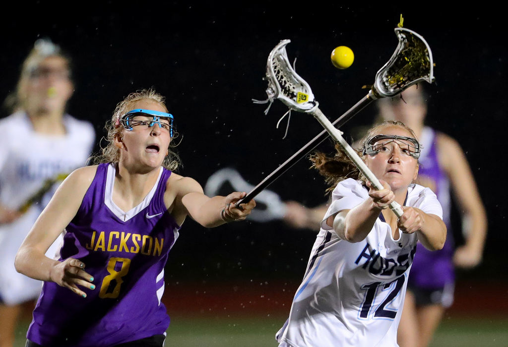 Sports - 1st place - Jackson's Chelsea Debevec (left) and Hudson's Emily Ritenour eye down a loose ball during the second half of a lacrosse game in Hudson. (Jeff Lange / Akron Beacon Journal)