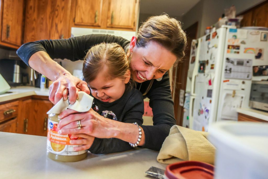 Feature - 1st place - Rachel Abke and her daughter Millie Abke, 5, attempt to open a jar of applesauce while gathering ingredients to make lavender cookies at their home in Perrysburg. Millie has an egg allergy, so the family, who has been participating in the Way Library Spice Club, substitutes applesauce in recipes. (Isaac Ritchey / The Blade)