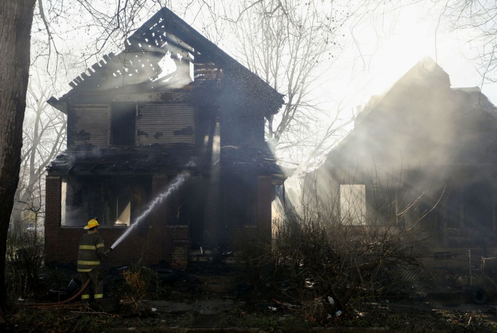 Spot News - HM - A firefighter sprays water on one of the two house that caught on fire on the 600 block of Federal Street in East Toledo. (Kurt Steiss / The Blade)